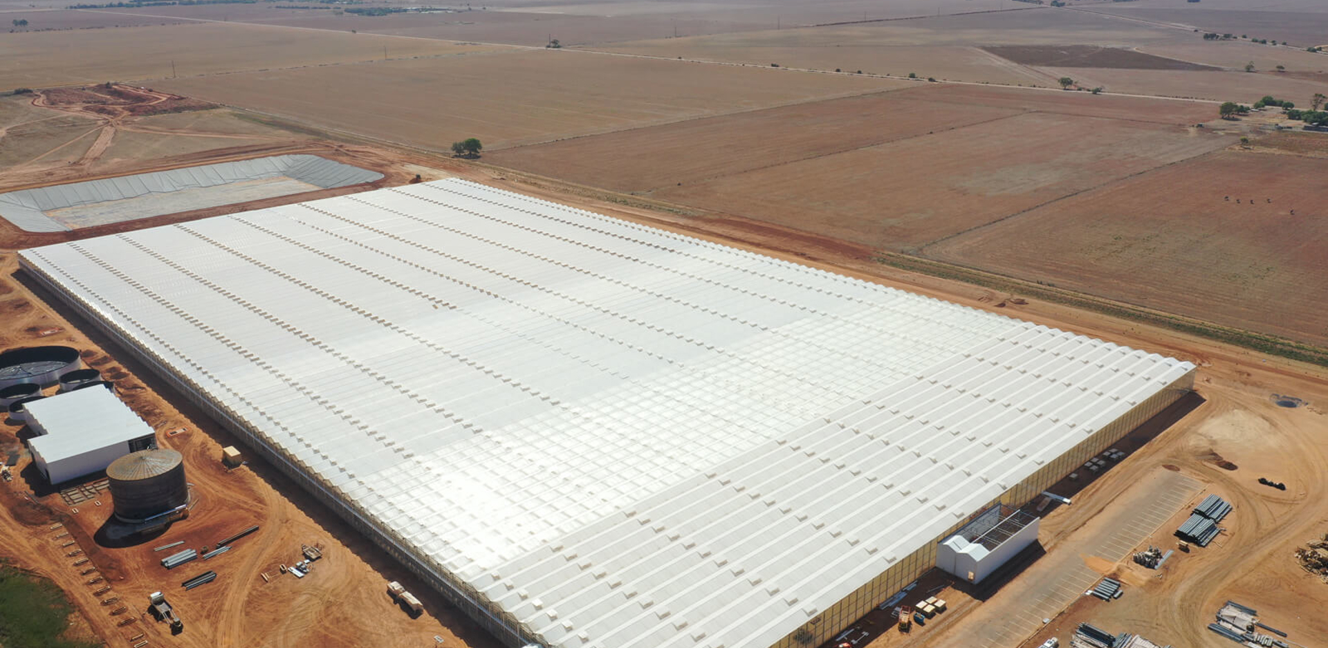 Luchtfoto van de Perfection kassenfaciliteit, omringd door uitgestrekte droge landbouwgrond in Australië.